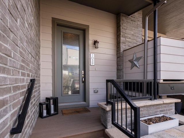 doorway to property featuring brick siding