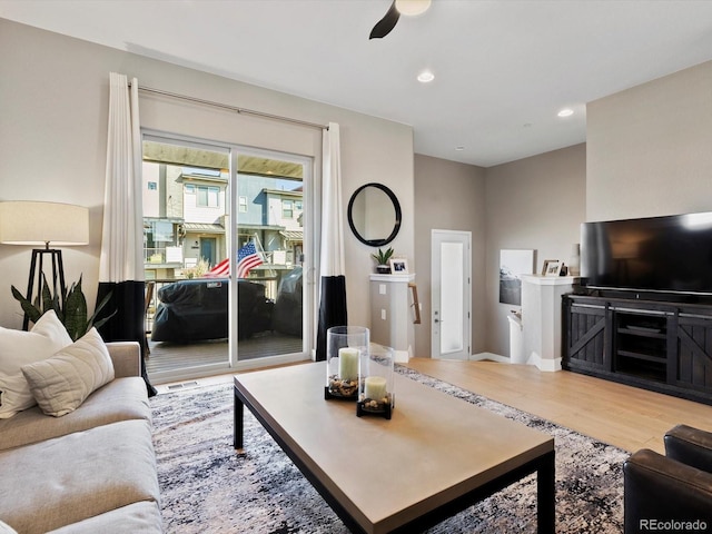 living room featuring a ceiling fan, recessed lighting, and wood finished floors