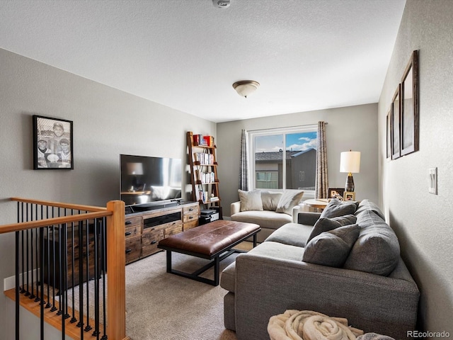 living area with a textured ceiling, carpet flooring, and a textured wall