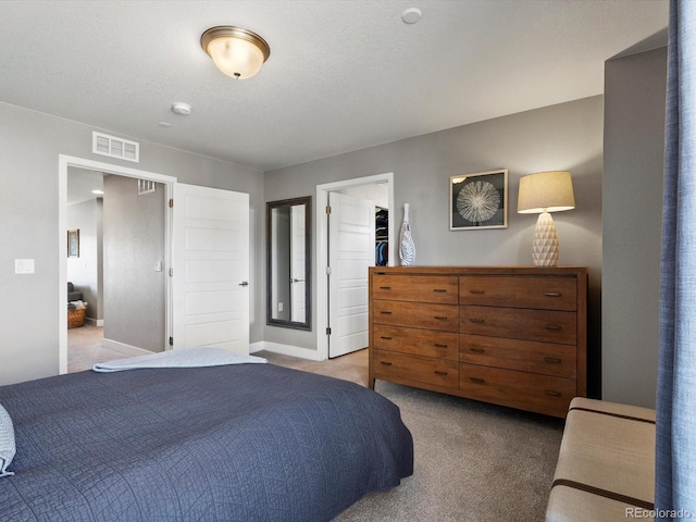 bedroom featuring carpet floors, baseboards, a spacious closet, and visible vents