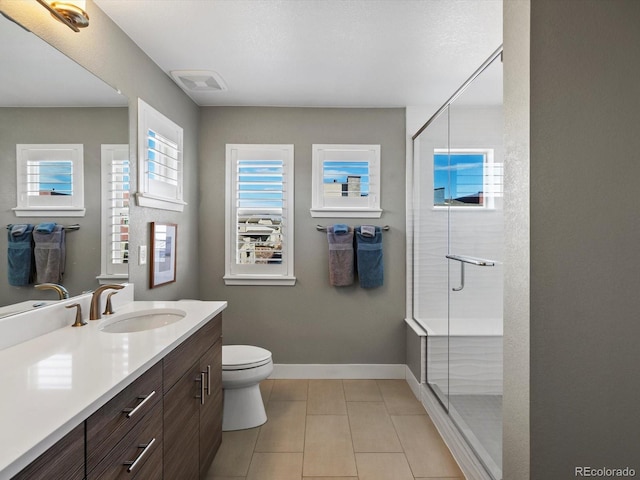 full bath with toilet, visible vents, vanity, baseboards, and a stall shower