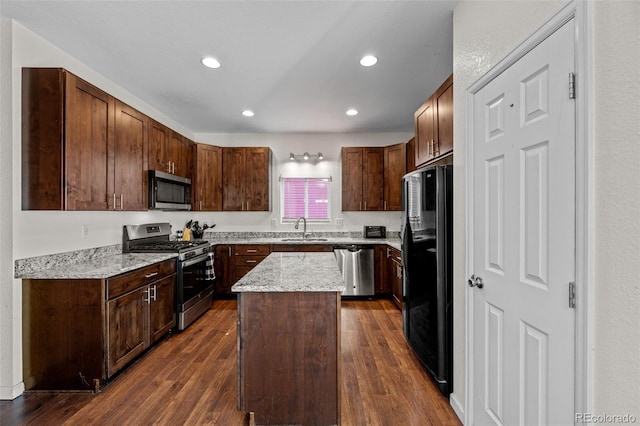 kitchen with recessed lighting, stainless steel appliances, a sink, a center island, and dark wood finished floors