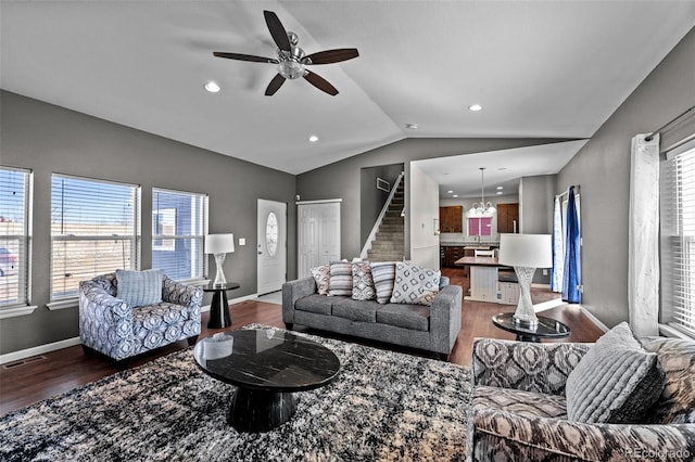 living area featuring wood finished floors, visible vents, baseboards, vaulted ceiling, and stairway