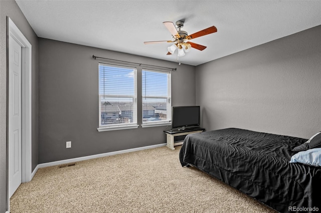 bedroom with visible vents, baseboards, a ceiling fan, a textured ceiling, and carpet flooring