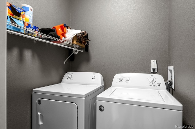 laundry room featuring a textured wall, laundry area, and washer and clothes dryer