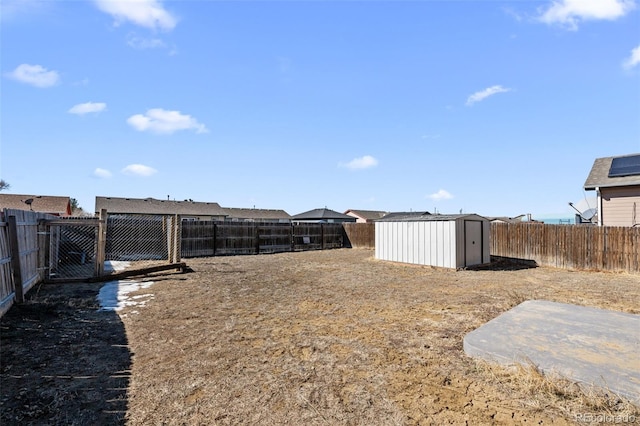 view of yard featuring a fenced backyard, a storage unit, and an outdoor structure