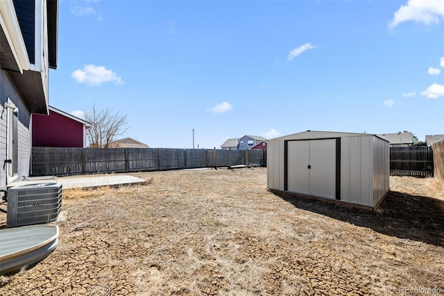 view of yard featuring an outbuilding, a shed, a fenced backyard, and cooling unit