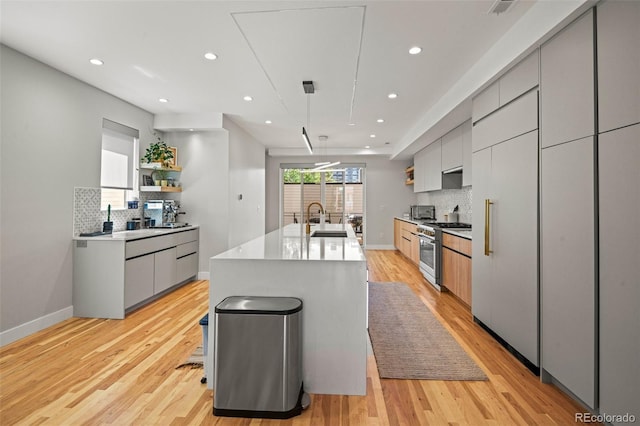 kitchen featuring open shelves, modern cabinets, high end stainless steel range oven, and a sink