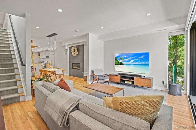 living area featuring recessed lighting, wood finished floors, and stairs