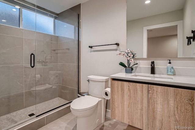 bathroom with a stall shower, toilet, and vanity