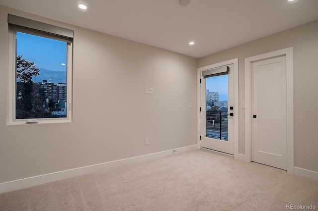 empty room with recessed lighting, baseboards, and light carpet