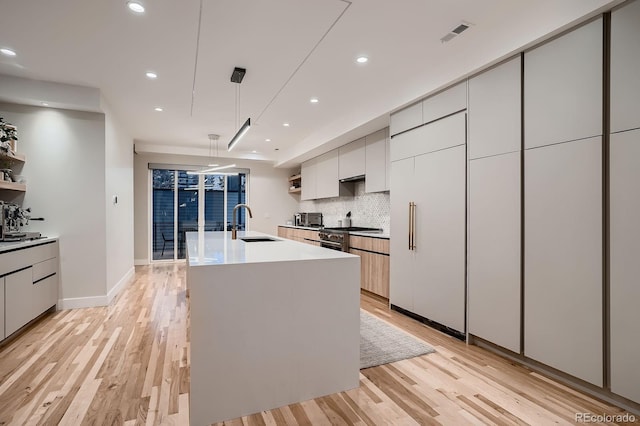 3232 W 16th Ave, Denver, CO 80204 - kitchen featuring modern cabinets, light wood-style floors, tasteful backsplash, and recessed lighting