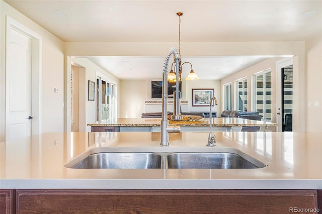 7172 S Oakleaf St, Bennett, CO 80102 - kitchen featuring a sink, open floor plan, pendant lighting, and light stone counters