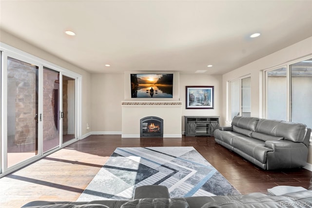 7172 S Oakleaf St, Bennett, CO 80102 - living area featuring recessed lighting, baseboards, a warm lit fireplace, and wood finished floors