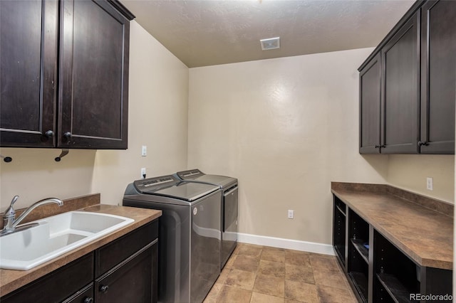 7172 S Oakleaf St, Bennett, CO 80102 - washroom with visible vents, baseboards, separate washer and dryer, a sink, and cabinet space