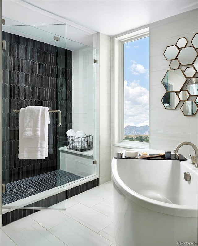 bathroom with plenty of natural light, tile floors, independent shower and bath, and a mountain view