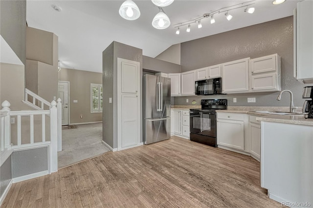 21789 Farmingdale Way, Parker, CO 80138 - kitchen featuring black appliances, vaulted ceiling, light countertops, light wood finished floors, and white cabinets