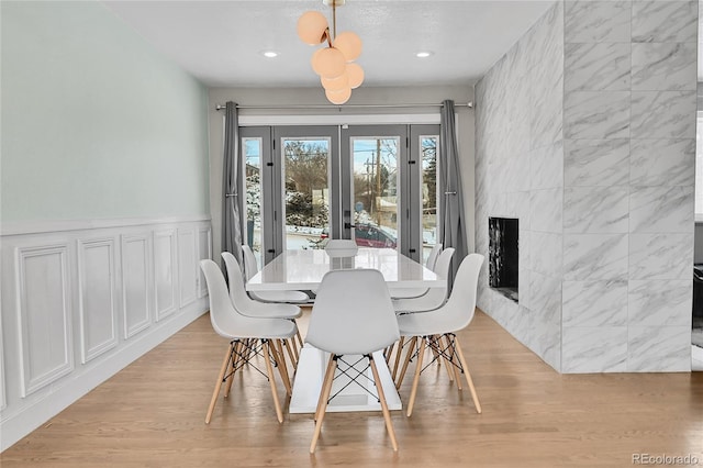 dining room featuring a premium fireplace and light wood-type flooring