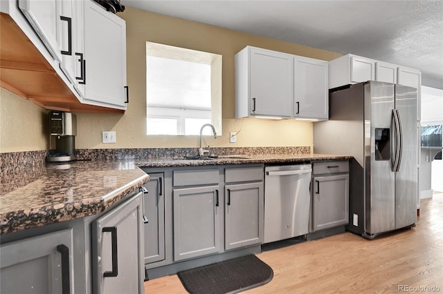 kitchen with light wood-type flooring, sink, gray cabinets, and appliances with stainless steel finishes