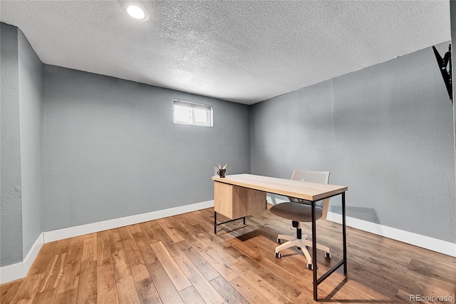 home office featuring wood-type flooring and a textured ceiling