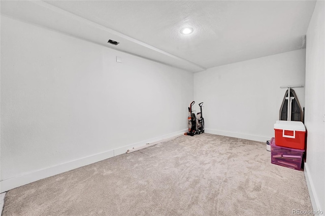 interior space featuring light carpet and a textured ceiling