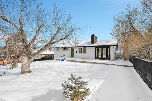 view of snow covered back of property