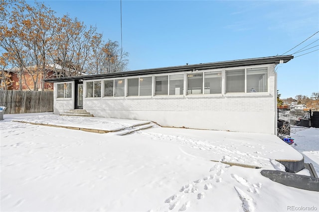 9040 Yucca Way, Thornton, CO 80229 - snow covered house featuring brick siding and entry steps