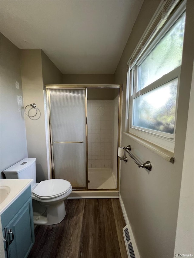 bathroom with vanity, wood-type flooring, an enclosed shower, and toilet