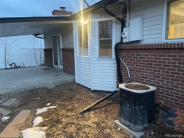 view of side of home with cooling unit and a patio