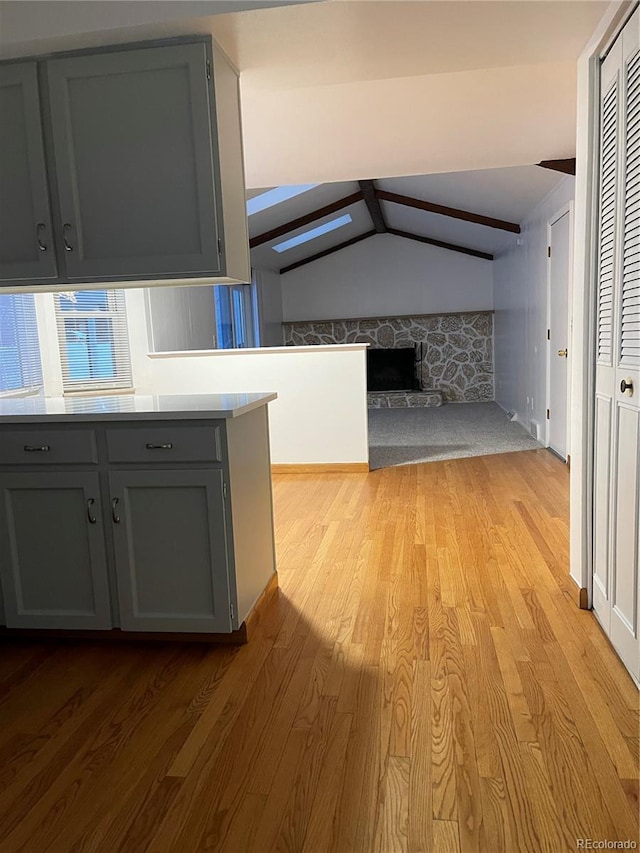 hall featuring light wood-type flooring and lofted ceiling with skylight