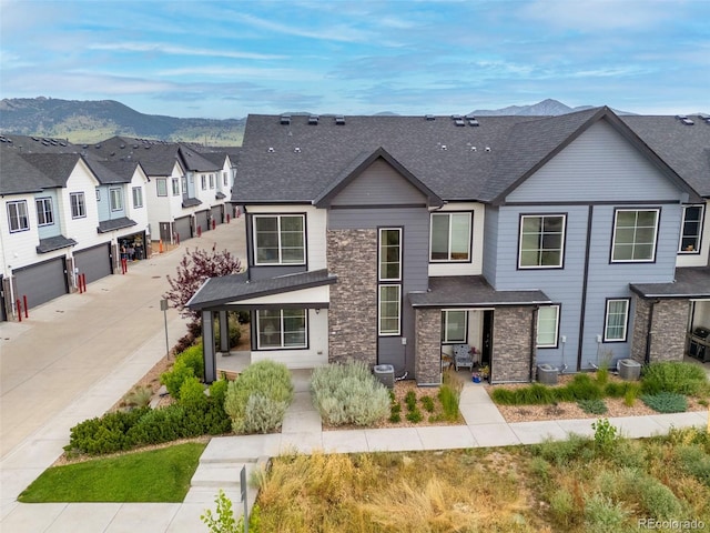 9284 Gore St Unit A, Arvada, CO 80007 - view of front of house featuring roof with shingles, a mountain view, a residential view, concrete driveway, and stone siding