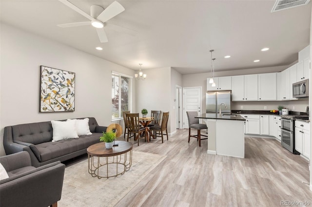 9284 Gore St Unit A, Arvada, CO 80007 - living area with light wood-type flooring, recessed lighting, a chandelier, and a ceiling fan
