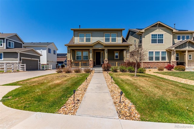 view of front of home with a porch, stone siding, a front yard, and a garage