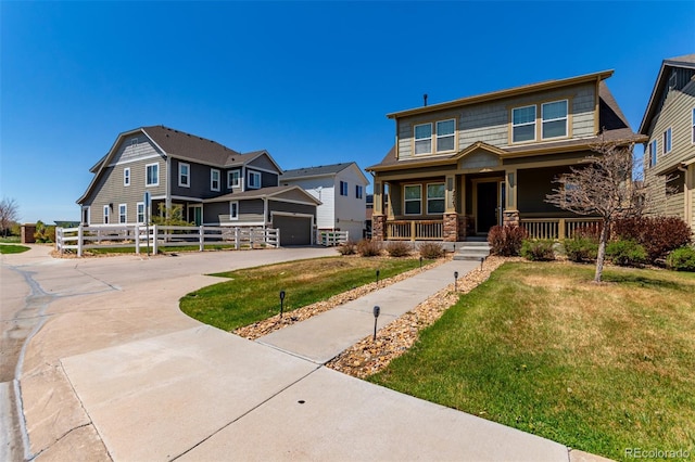 view of front facade featuring a porch, driveway, a front yard, stone siding, and a garage