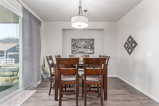 dining space with wood finished floors and baseboards
