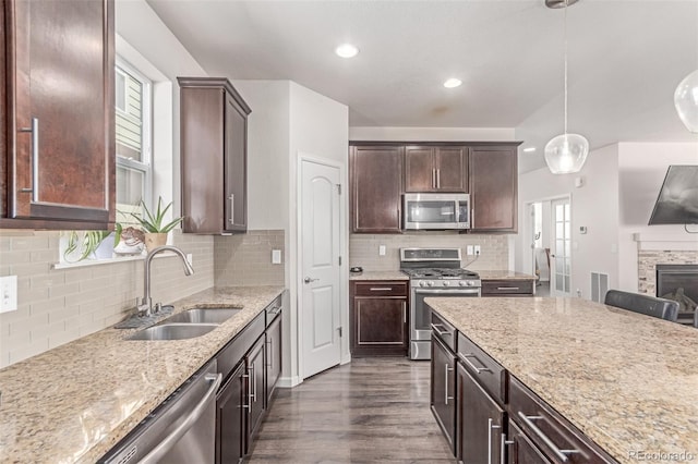 kitchen featuring appliances with stainless steel finishes, a sink, plenty of natural light, dark wood finished floors, and recessed lighting