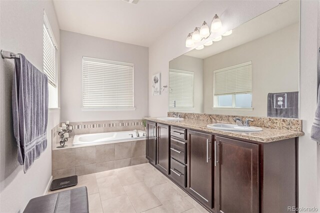 bathroom featuring tile patterned floors, a bath, and double vanity