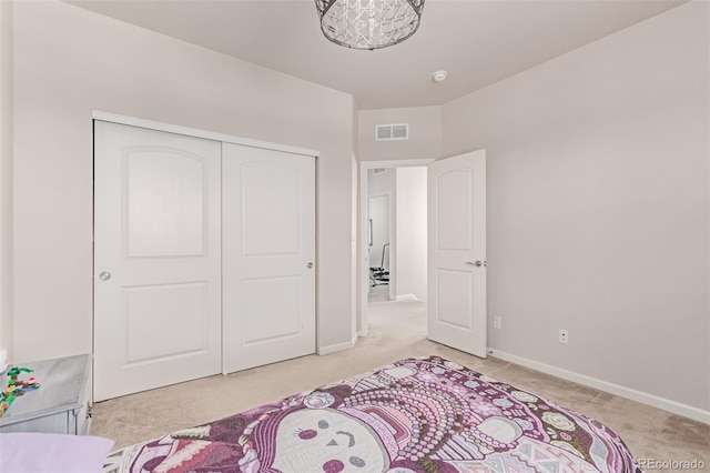 bedroom featuring light colored carpet, baseboards, and a closet
