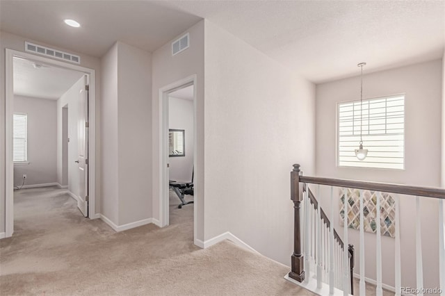 hallway featuring an upstairs landing, carpet flooring, and baseboards