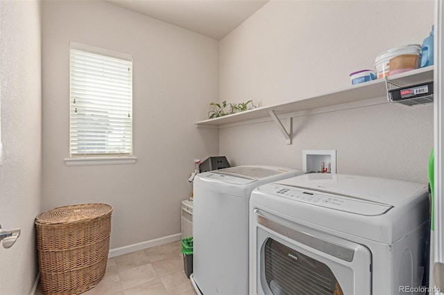 washroom with washer and clothes dryer and baseboards