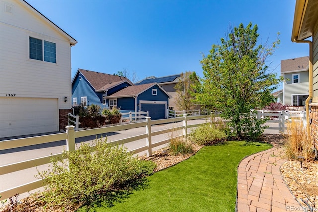 view of yard featuring a garage and a residential view