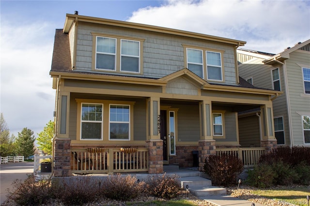 craftsman-style home featuring covered porch and stone siding