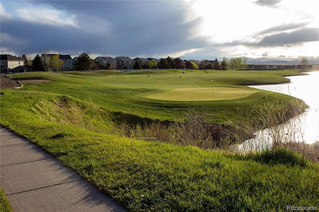 view of home's community featuring a residential view, a water view, a putting area, and view of golf course