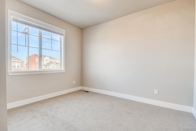 spare room with visible vents, baseboards, and carpet