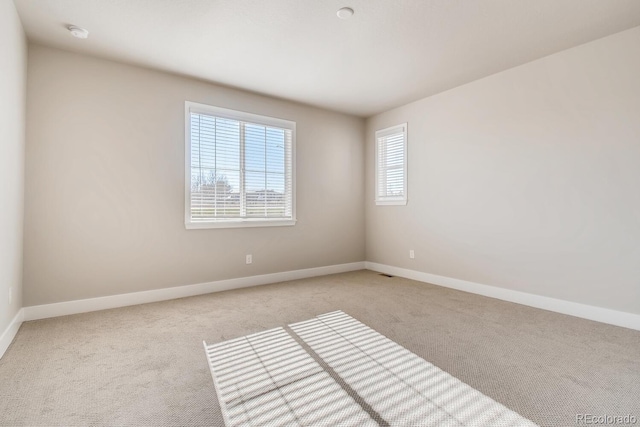 spare room featuring carpet flooring and baseboards