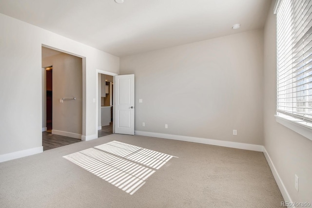 carpeted spare room featuring baseboards