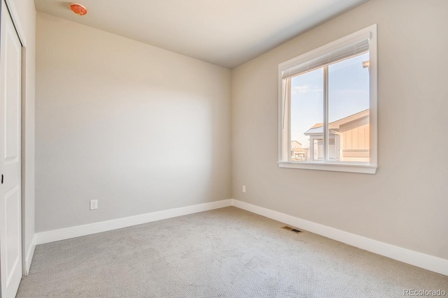 carpeted empty room with baseboards and visible vents