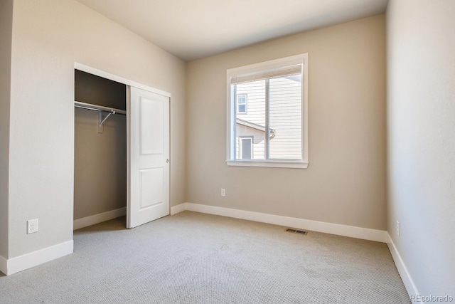 unfurnished bedroom with baseboards, a closet, visible vents, and carpet