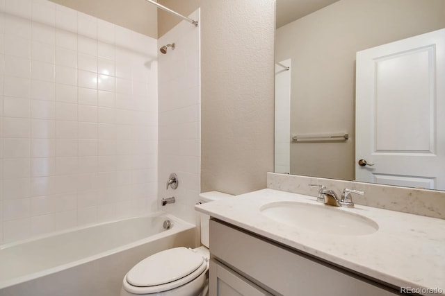 bathroom with washtub / shower combination, a textured wall, toilet, and vanity