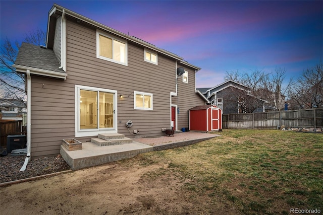 back of house with a patio, an outbuilding, fence, a yard, and a shed